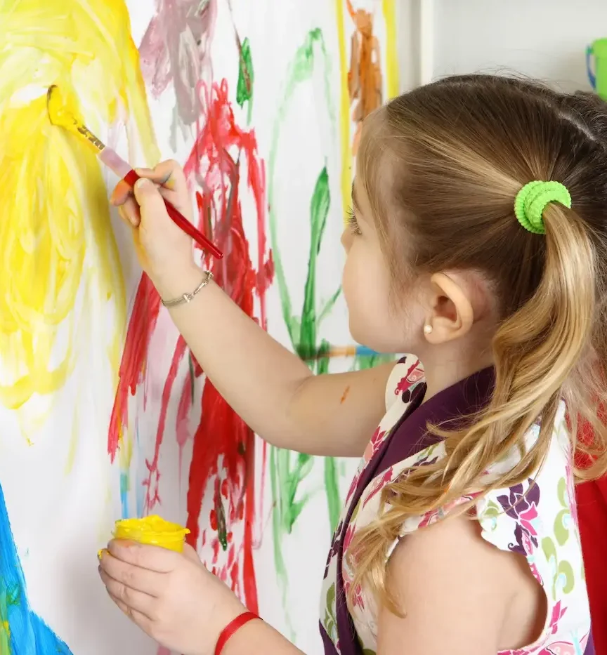 A student painting at an easel during a learning program