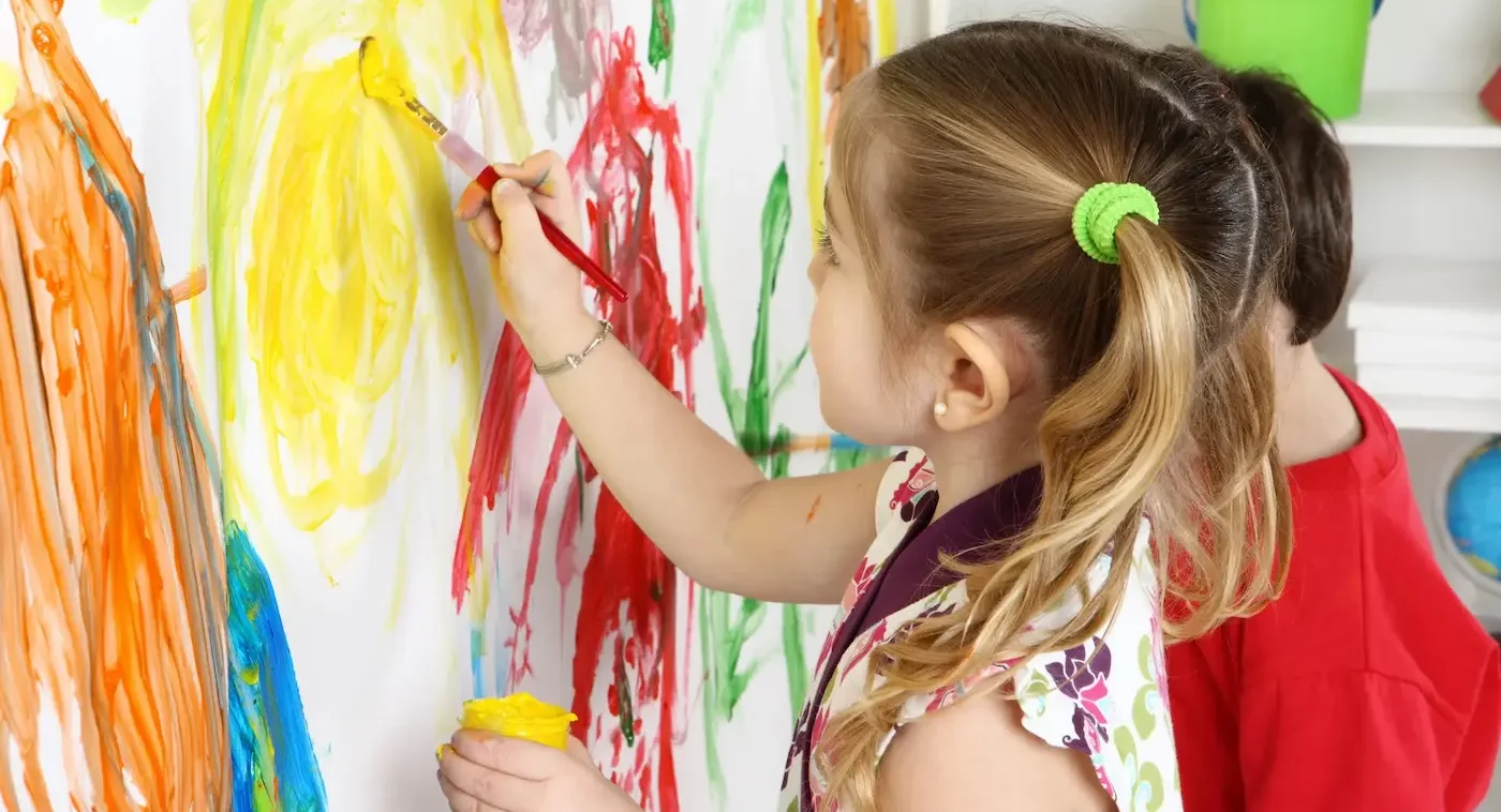 A student painting at an easel during a learning program