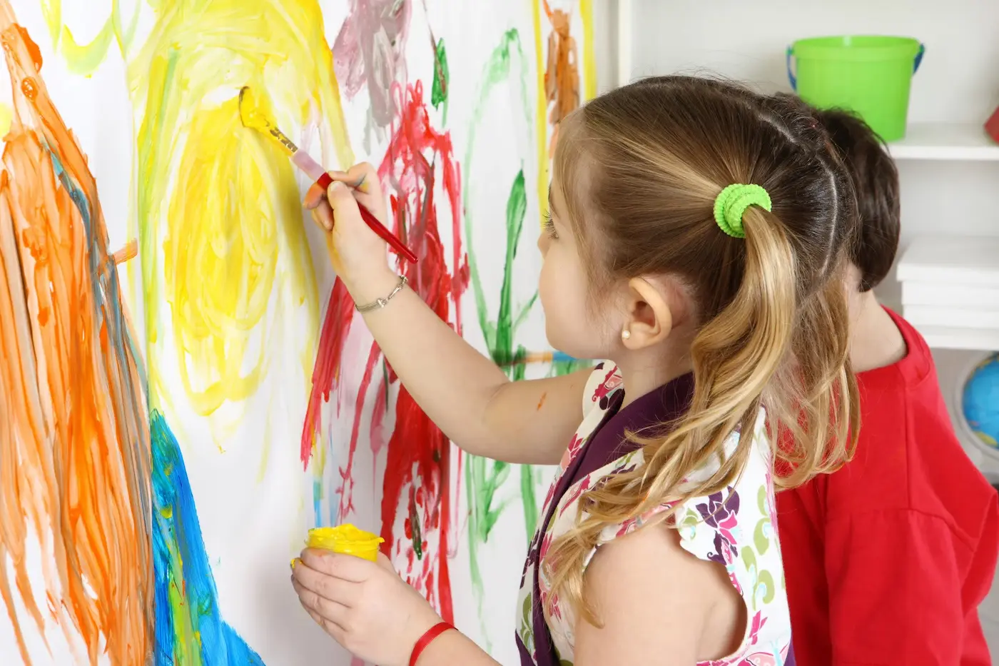 A student painting at an easel during a learning program