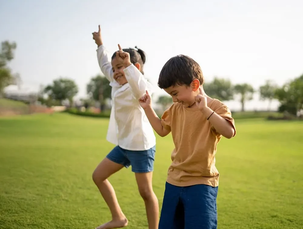 Children dancing on a lawn after class