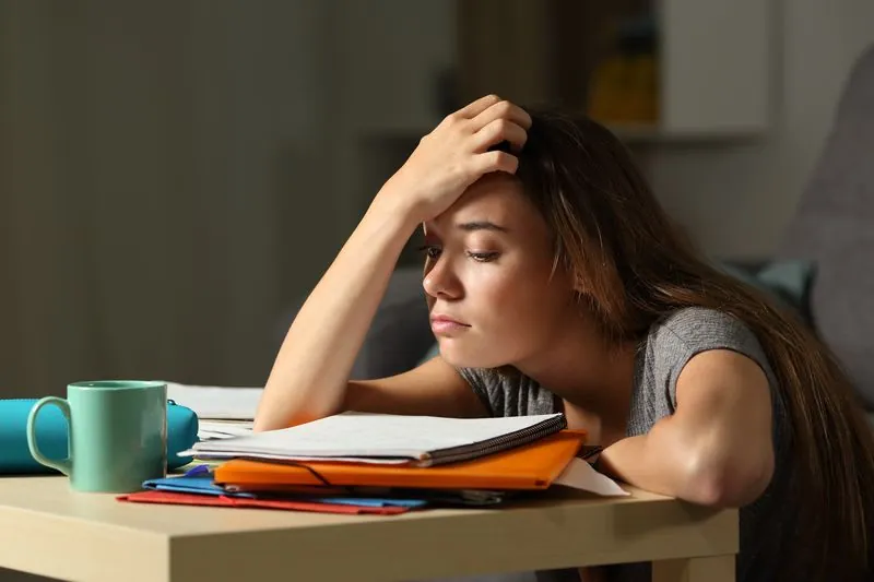 A student resting her head in her hand at a desk