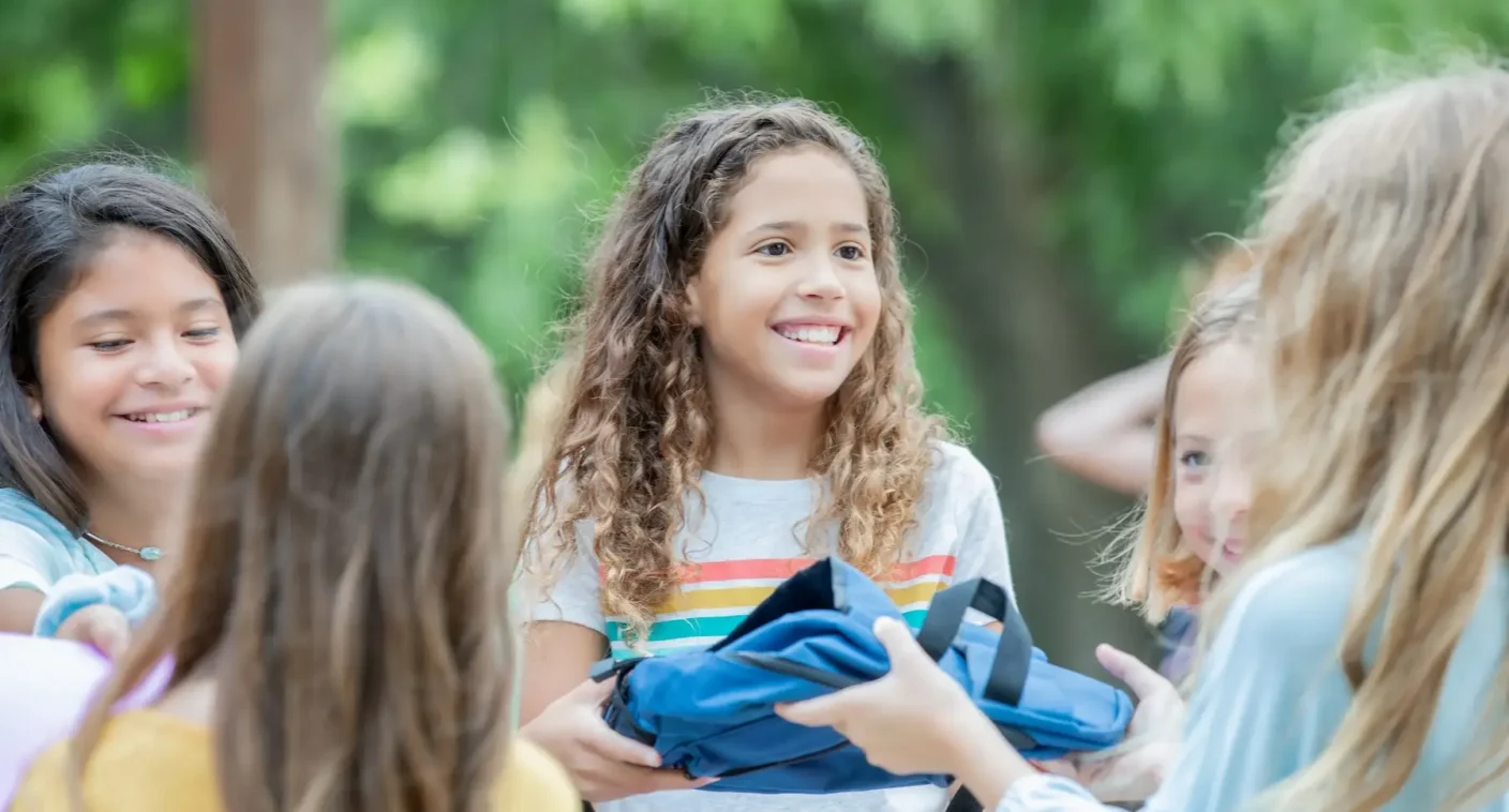 Middle school students talking and smiling outdoors