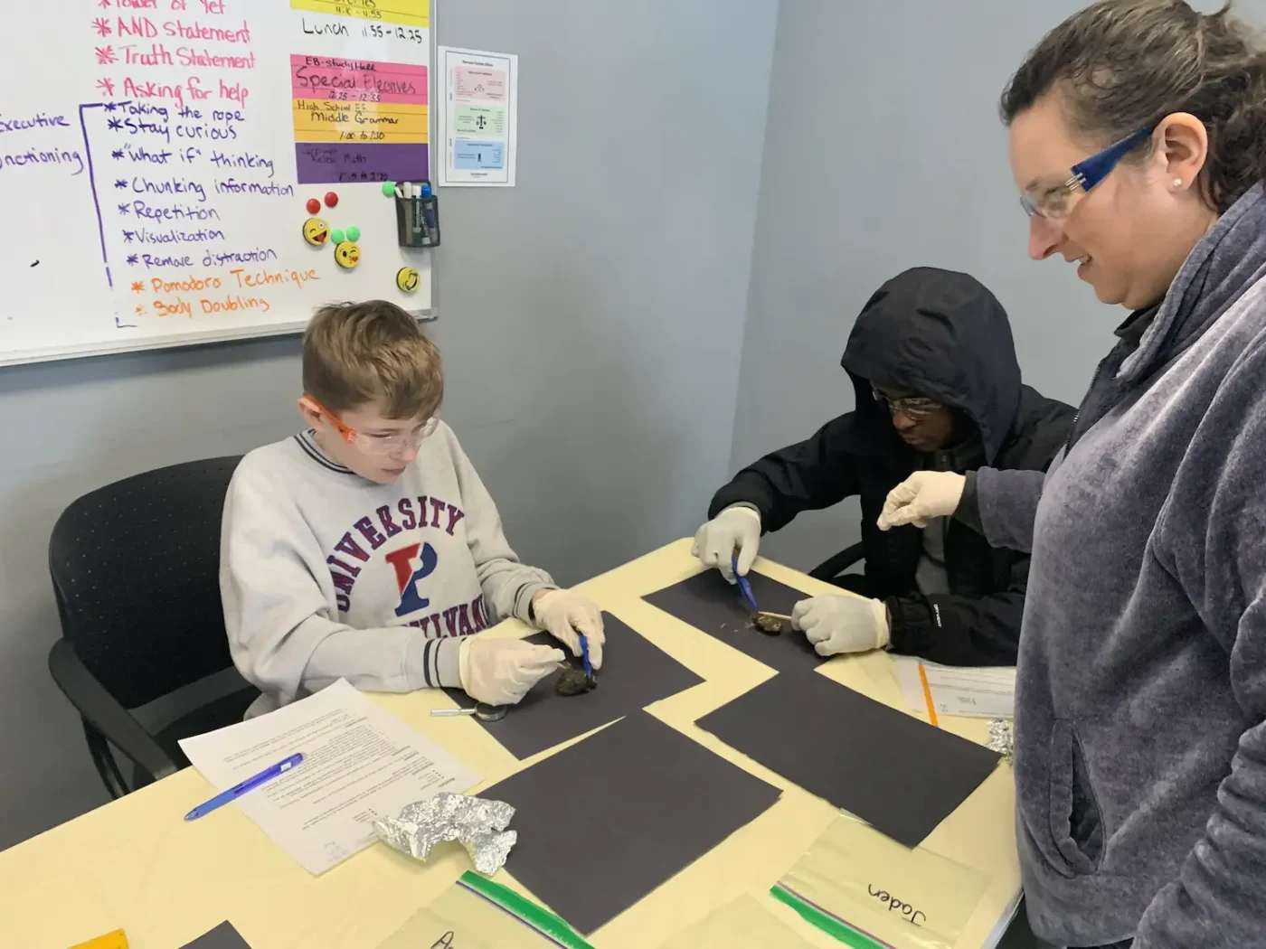 A teacher working with two students on a hands-on project at Balanced Learning Academy