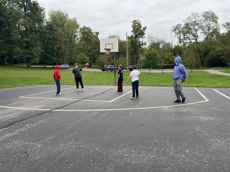Students playing basketball outside the academy