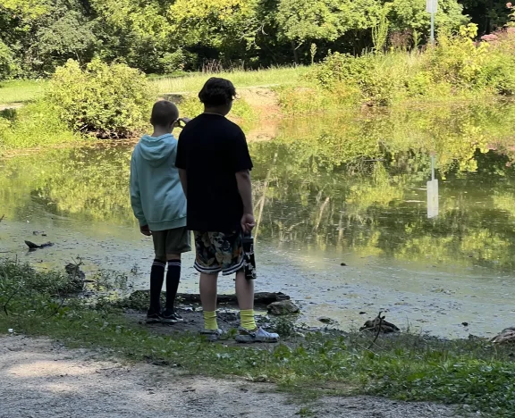 Students on a nature walk by a pond